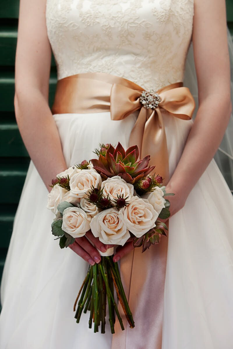 Bride wearing ivory and white wedding dress with golden orange